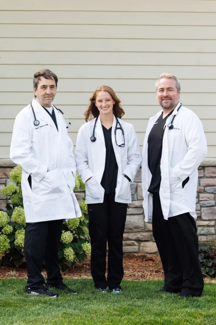Dr. Mark Stavros, Dr. Ashley Skarda and Dr. Christopher Tate in white coats outside the hospital